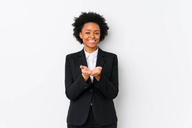 Orta yaşlı Afrikalı Amerikalı iş kadını beyaz bir arka plana karşı izole edilmiş, avuç içli bir şey tutuyor ve kameraya sunuyor..