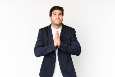 Beyaz arka planda izole edilmiş genç bir iş adamı. El ele tutuşup dua ediyor. Kendine güveniyor..