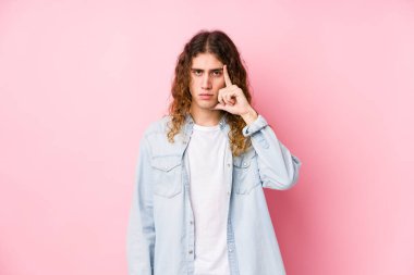 Uzun saçlı adam kendini soyutlamış, parmağıyla işaret ediyor, düşünüyor ve bir göreve odaklanıyor..