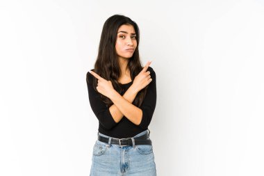 Mor arka planda izole edilmiş genç Hintli kadın iki seçenekten birini seçmeye çalışıyor..