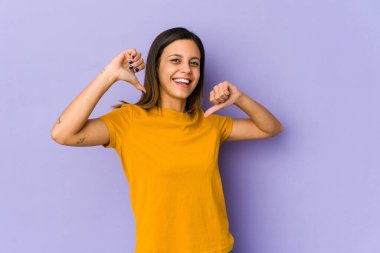 Mor arka planda izole edilmiş genç bir kadın gururlu ve kendinden emin hissediyor, örnek olarak.