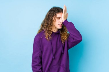 Uzun saçlı adam yalnız poz veriyor. Bir şeyi unutuyor. Alnına avuç içi ve gözlerini kapatıyor..