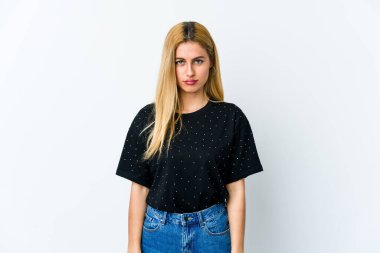 Genç sarışın kadın beyaz arka planda izole edilmiş üzgün, ciddi yüzlü, mutsuz ve hoşnutsuz..