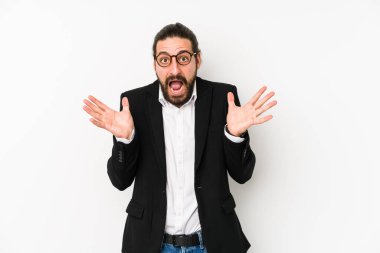 Kafkasyalı genç iş adamı, beyaz bir arkaplanda zaferi ya da başarıyı kutlarken, şaşırdı ve şok oldu..