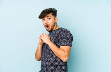 Genç Arap adam mavi bir arka planda izole edilmiş korkmuş ve korkmuş..