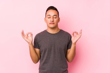 Yoong latin adam pembe arka planda poz veriyor. Sıkı çalışma gününden sonra yoga yapıyor..