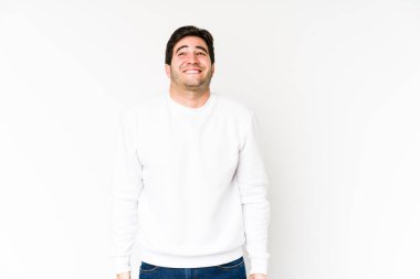 Beyaz arka planda soyutlanmış genç adam gülüyor ve gözlerini kapıyor, rahatlamış ve mutlu hissediyor..