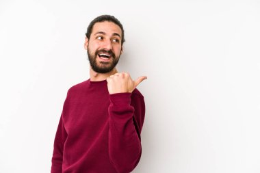 Uzun saçlı genç adam beyaz bir arka planda izole edilmiş, başparmak uzakta, gülüyor ve kaygısız..