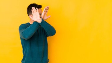 Kafkasyalı genç adam sarı fırında izole edilmiş iki kolu çapraz tutuyor, inkar kavramı.