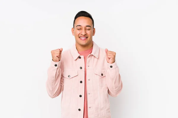 Молодой Латинский Мужчина Позирует Изолированно Поднимая Кулак Чувствуя Себя Счастливым — стоковое фото