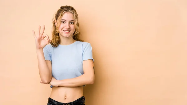 Joven Mujer Caucásica Aislada Sobre Fondo Beige Guiña Ojo Sostiene —  Fotos de Stock