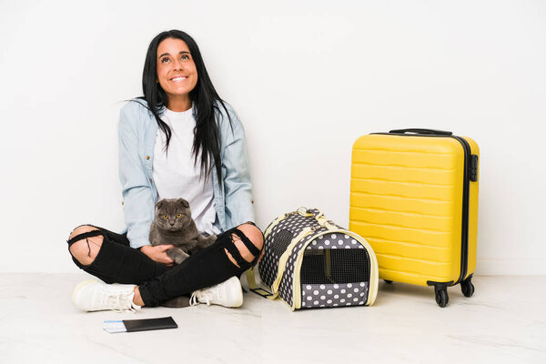 Traveler woman with her cat isolated on white background dreaming of achieving goals and purposes