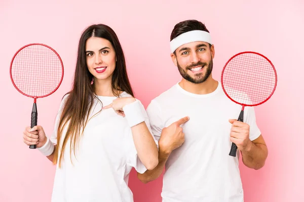 Casal Jovem Jogando Badminton Pessoa Isolada Apontando Mão Para Espaço — Fotografia de Stock