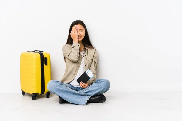 若いです中国の旅行者女性座っている搭乗券を持っています楽しいですカバー半分顔とともに手のひら — ストック写真