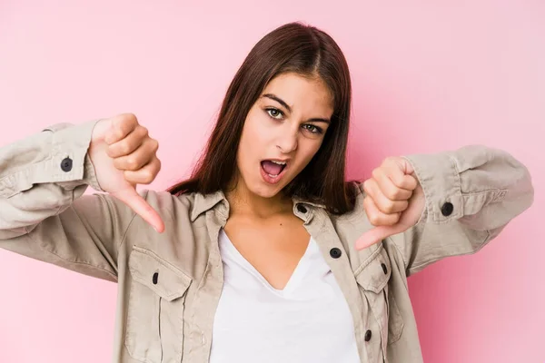 Pembe Arka Planda Poz Veren Beyaz Bir Kadın Baş Parmağını — Stok fotoğraf