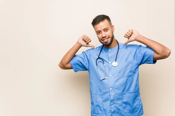 Young south-asian nurse man feels proud and self confident, example to follow.