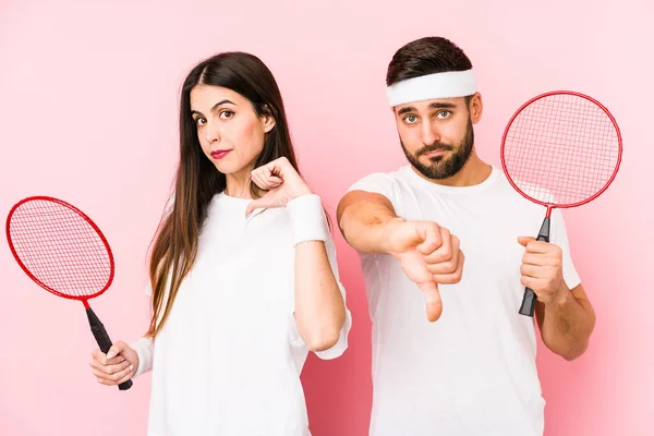 Casal Jovem Jogando Badminton Isolado Mostrando Gesto Antipatia Polegares Para — Fotografia de Stock