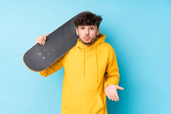 Jovem Árabe Skater Homem Isolado Encolhe Ombros Olhos Abertos Confuso — Fotografia de Stock