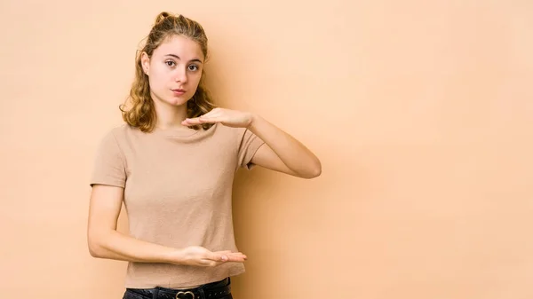 Ung Kaukasisk Kvinna Isolerad Beige Bakgrund Hålla Något Med Båda — Stockfoto