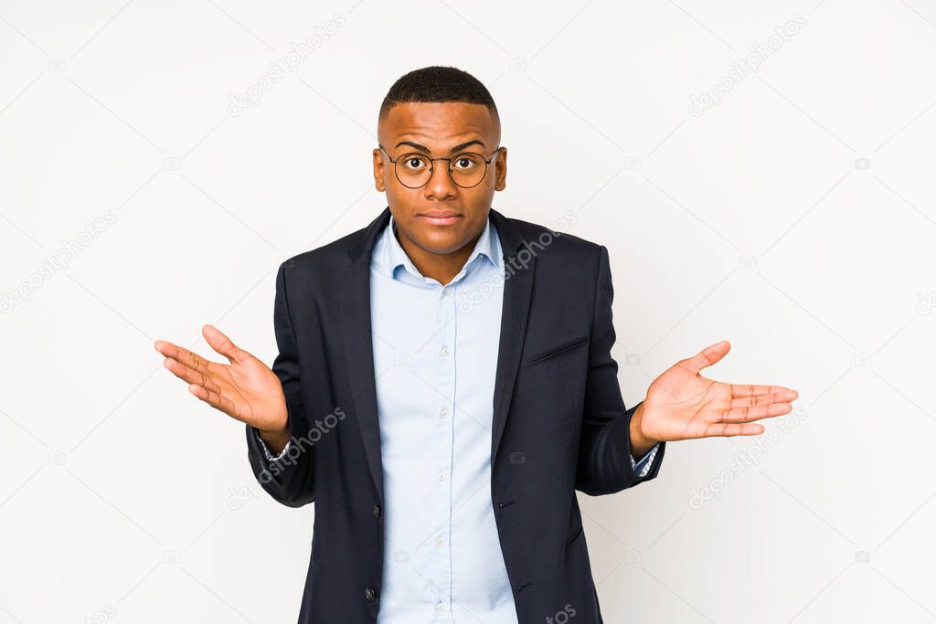 Young business latin man isolated on white background doubting and shrugging shoulders in questioning gesture.