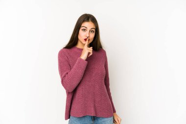 Beyaz arka planda izole edilmiş genç beyaz kadın ya sır saklıyor ya da sessizlik istiyor..