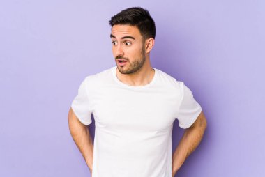 Mor arka planda izole edilmiş genç beyaz adam gördüğü bir şey yüzünden şoka uğruyor..