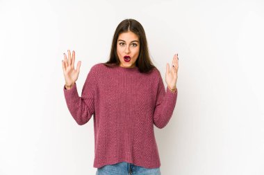 Beyaz arka planda izole genç beyaz kadın zaferi ya da başarıyı kutluyor, şaşırıyor ve şok oluyor..