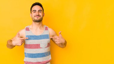 Beyaz tenli genç, sarı fırında izole edilmiş. Elle bir gömleğin fotokopi odasını işaret ediyor.