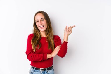 Kafkasyalı bir kadın yalnız poz veriyor. Gülümsüyor, işaret parmağıyla işaret ediyor..