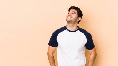 Bej arka planda izole edilmiş genç bir adam gevşemiş ve mutlu bir şekilde gülüyor, boynunda diş izleri var..