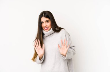 Beyaz bir arka planda izole edilmiş beyaz bir kadın, tiksinti belirtisi gösteren birini reddediyor..