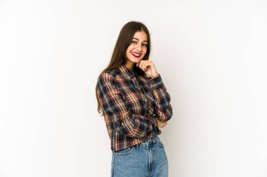 Beyaz arka planda izole edilmiş genç beyaz kadın mutlu ve kendinden emin gülümsüyor, elleriyle çenesine dokunuyor..