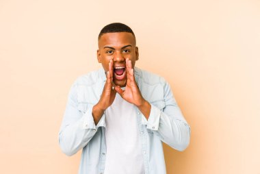 Genç latin adam bej arka planda izole edilmiş..