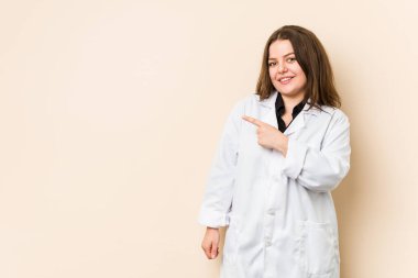 Genç doktor kadın gülümsüyor ve boş alanda bir şeyler gösteriyor..