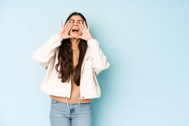 Mavi arka planda genç Hintli kadın heyecanla bağırıyor..