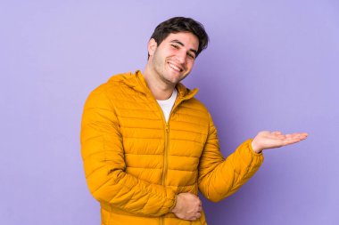 Mor arka planda izole edilmiş genç bir adam bir avuç içinde fotokopi alanı ve belinde başka bir el tutuyor..