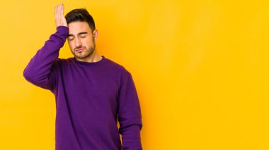 Kafkasyalı genç adam sarı fırında izole edilmiş yorgun ve uykulu bir şekilde ellerini başının üstünde tutuyor..