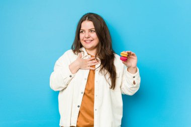 Kurabiye tutan genç kadin kahkahalarla gülüyor elini göğsüne koyuyor..