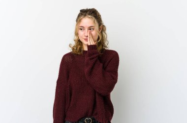 Beyaz arka plandaki genç beyaz kadın gizli bir sıcak fren haberi veriyor ve yan bakıyor.