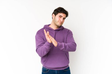 Genç adam beyaz arka planda izole edilmiş enerjik ve rahat hissediyor, ellerini ovuşturuyor kendinden emin..