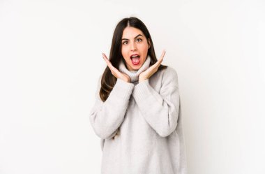 Beyaz arka planda izole genç beyaz kadın şaşırdı ve şok oldu..