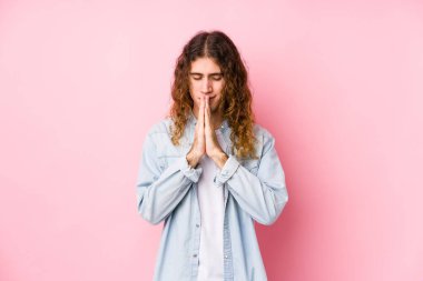 Uzun saçlı adam el ele tutuşup yalnız poz veriyor. Ağız kenarında dua ediyor. Kendine güveniyor..