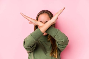 Kafkasyalı genç bir kadın yalnız poz veriyor iki kolu çapraz tutuyor, inkar kavramı.