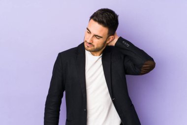 Mor arka planda izole olmuş genç beyaz bir adam stresten dolayı boynu ağrıyor, masaj yapıyor ve elle dokunuyor..