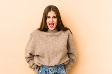 Beyazlı genç bir kadın bej arka planda izole edilmiş. Gördüğü bir şey yüzünden şok oluyor..