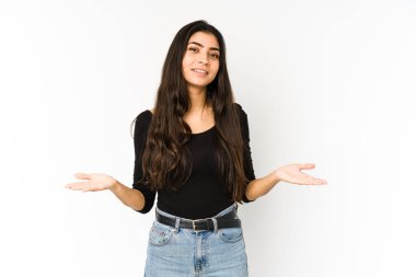 Mor arka planda izole edilmiş genç Hintli kadın kollarıyla ölçeği yapıyor, mutlu ve kendinden emin hissediyor..