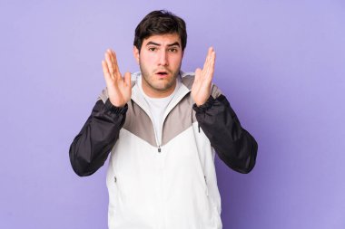 Mor arka planda izole genç adam şaşırdı ve şok oldu..