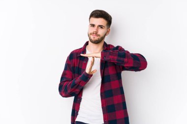 Beyaz arka planda poz veren beyaz tenli genç bir adam tecrit edilmiş bir jest yapıyor..