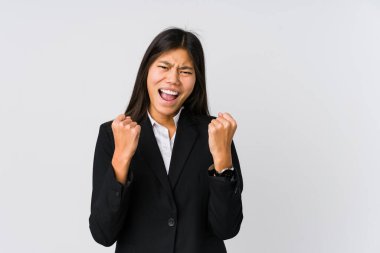 Asyalı genç iş kadını gamsız ve heyecanlı bir şekilde tezahürat yapıyor. Zafer konsepti.