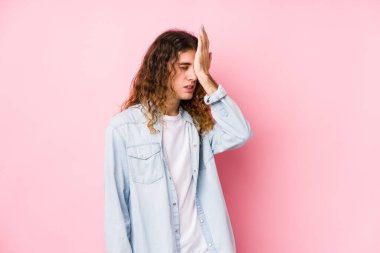 Uzun saçlı adam yalnız poz veriyor. Bir şeyi unutuyor. Alnına avuç içi ve gözlerini kapatıyor..